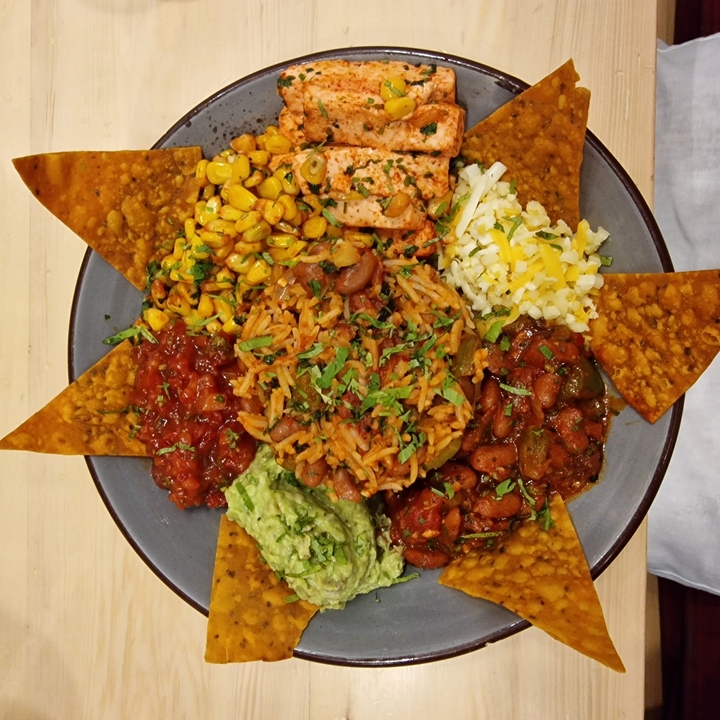 Assiette de plats mexicains variés incluant du riz et de la salsa.