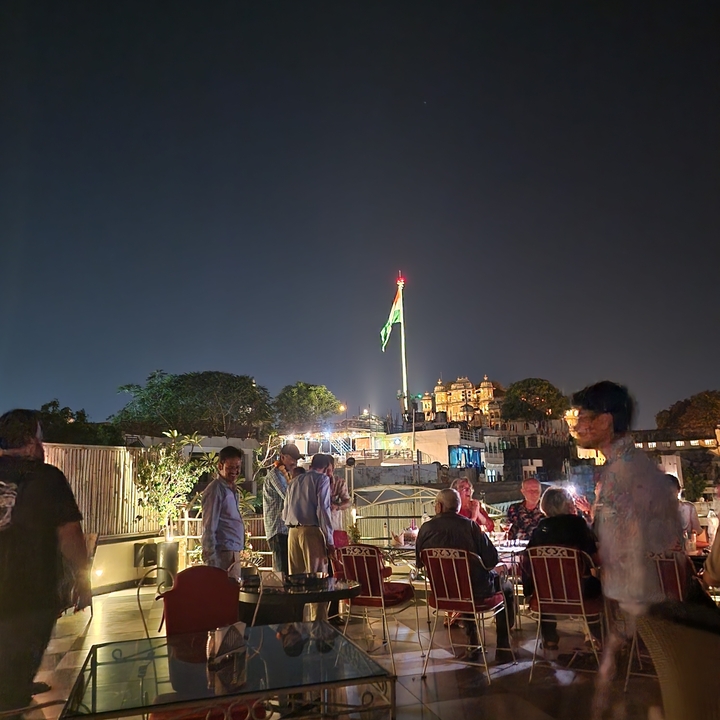 Rassemblement social du soir avec un grand drapeau en arrière-plan.