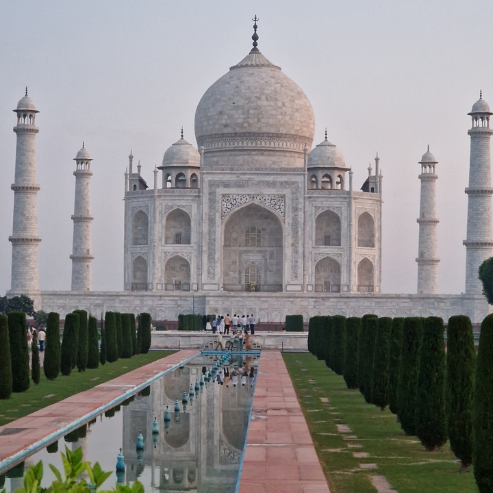 Taj Mahal avec des visiteurs qui se promènent au premier plan.