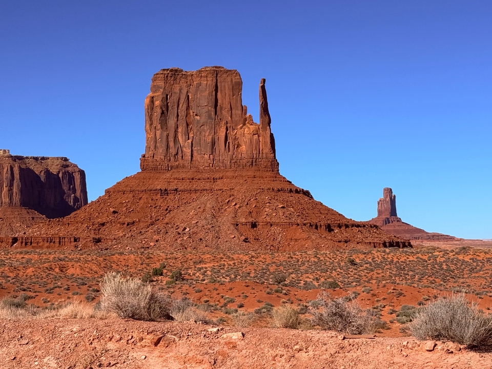 Des formations emblématiques de buttes rouges sous un ciel bleu dégagé.