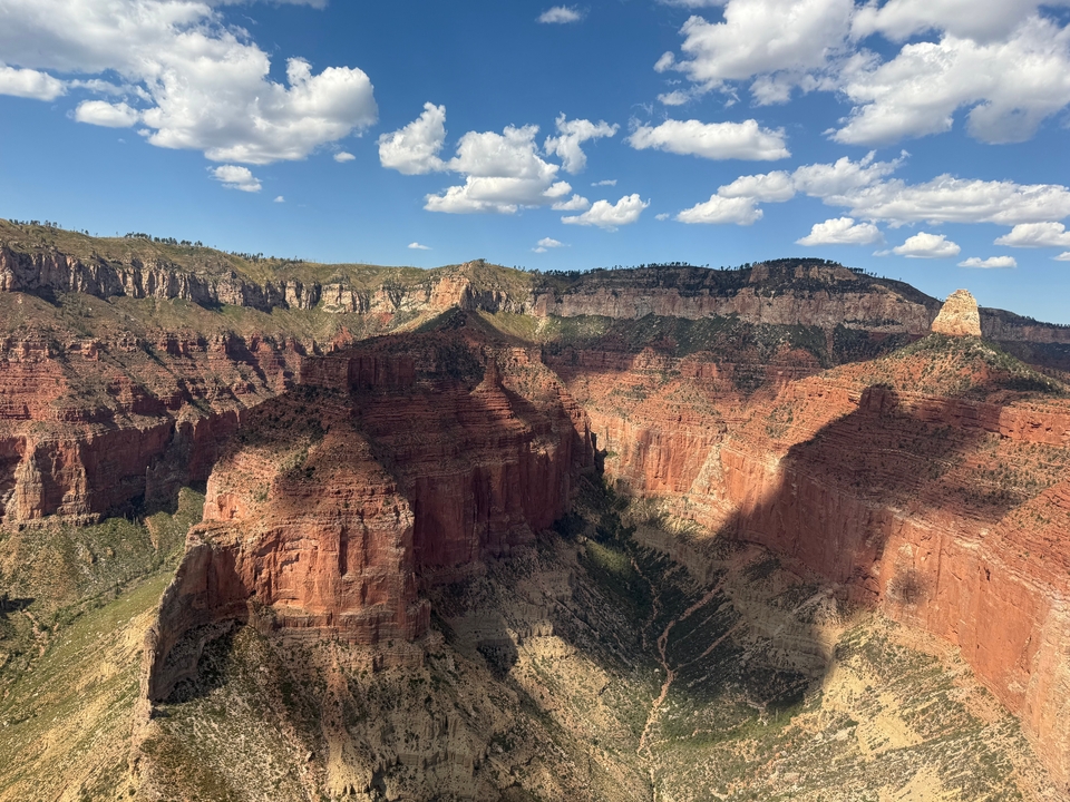 Vue aérienne du vaste Grand Canyon baigné de soleil, révélant de profondes ombres.