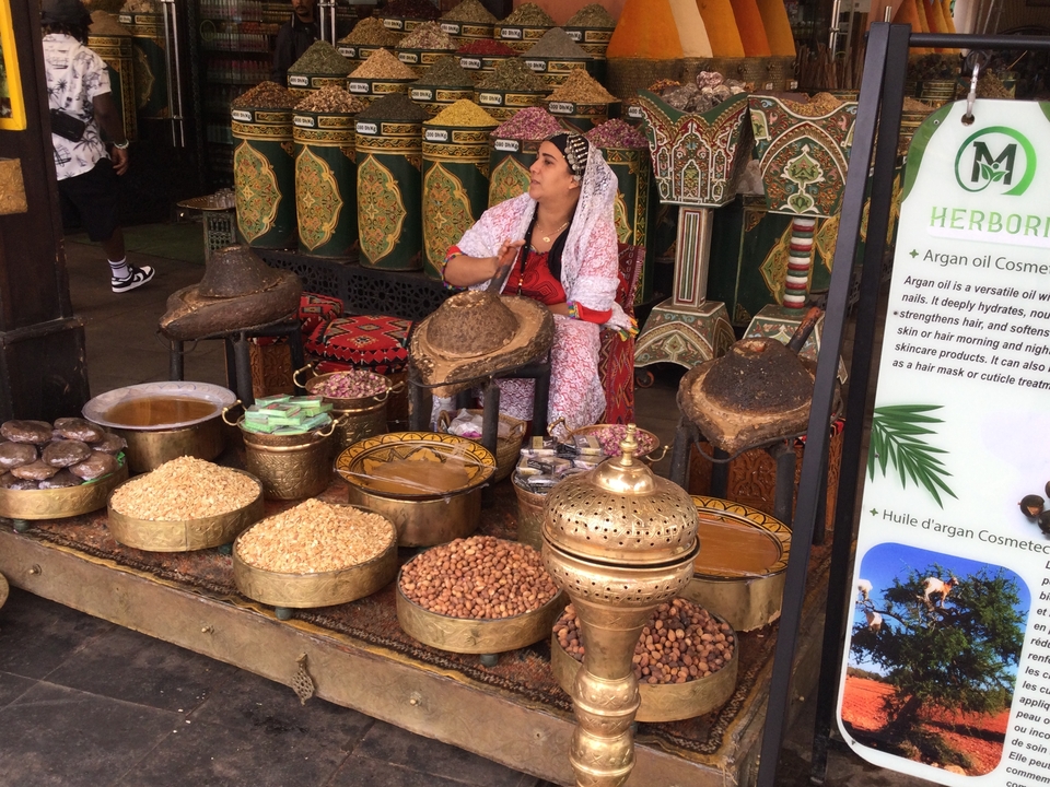 Étal de marché avec des noix, des huiles et des décorations traditionnelles.