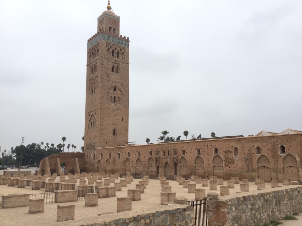 Mosquée avec haut minaret et cour en pierre.