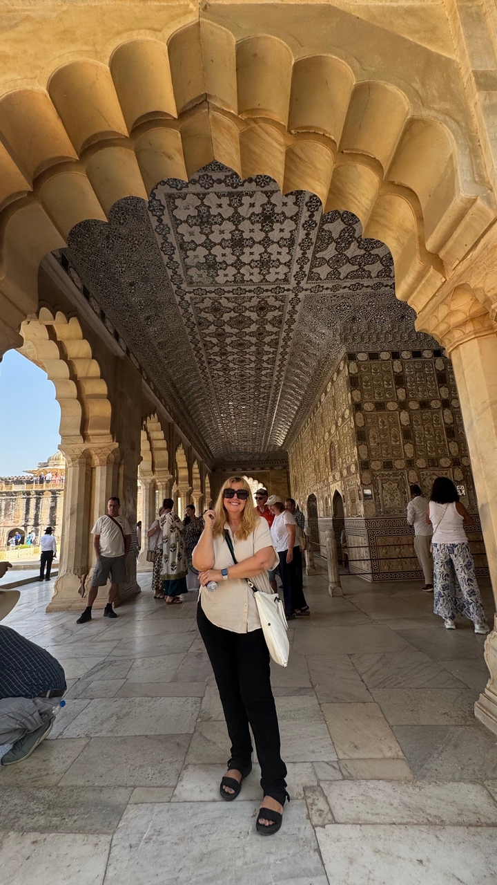 Personne debout dans un couloir décoratif aux motifs complexes.