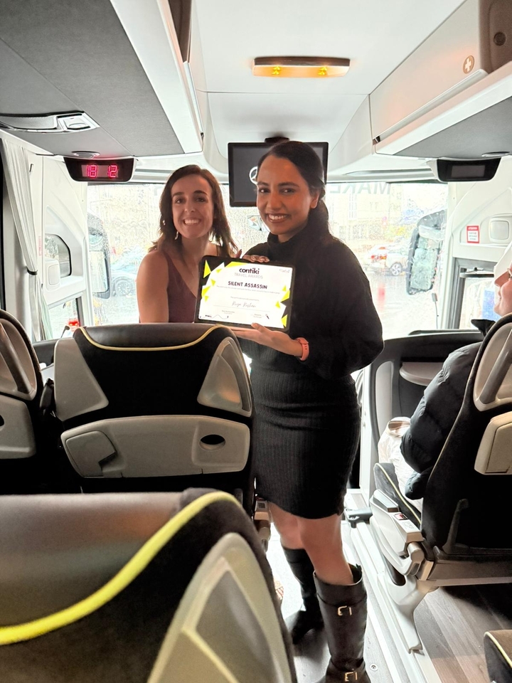 Deux femmes à l'intérieur d'un bus tenant un certificat en souriant.