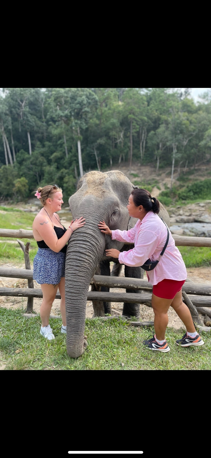 Deux femmes interagissant avec un éléphant dans un cadre naturel.