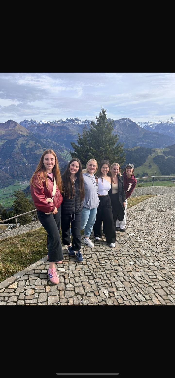 Groupe de jeunes femmes posant sur un flanc de colline montagneux.