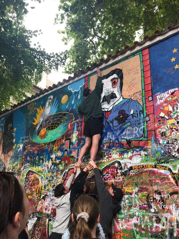 Personne grimpant et interagissant avec un mur de graffitis coloré.