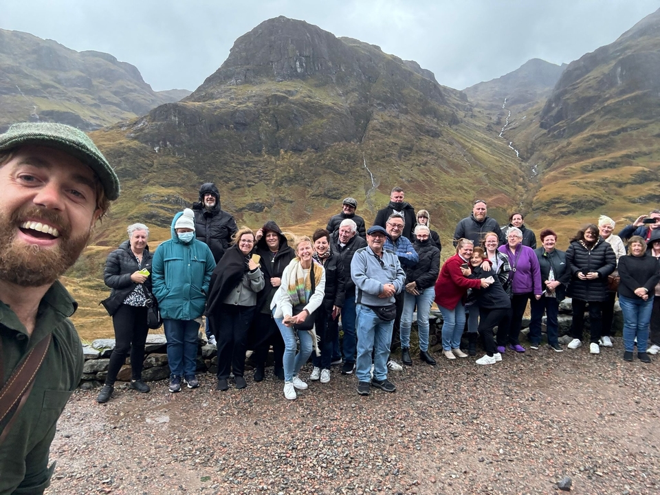 Groupe posant devant un paysage montagneux.