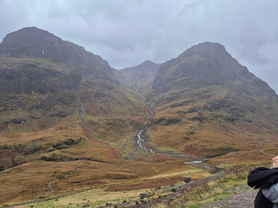 Vallée avec des collines escarpées et un groupe de personnes qui posent.