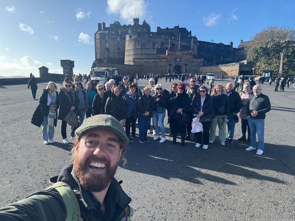 Groupe de personnes dans un château historique par une journée ensoleillée.