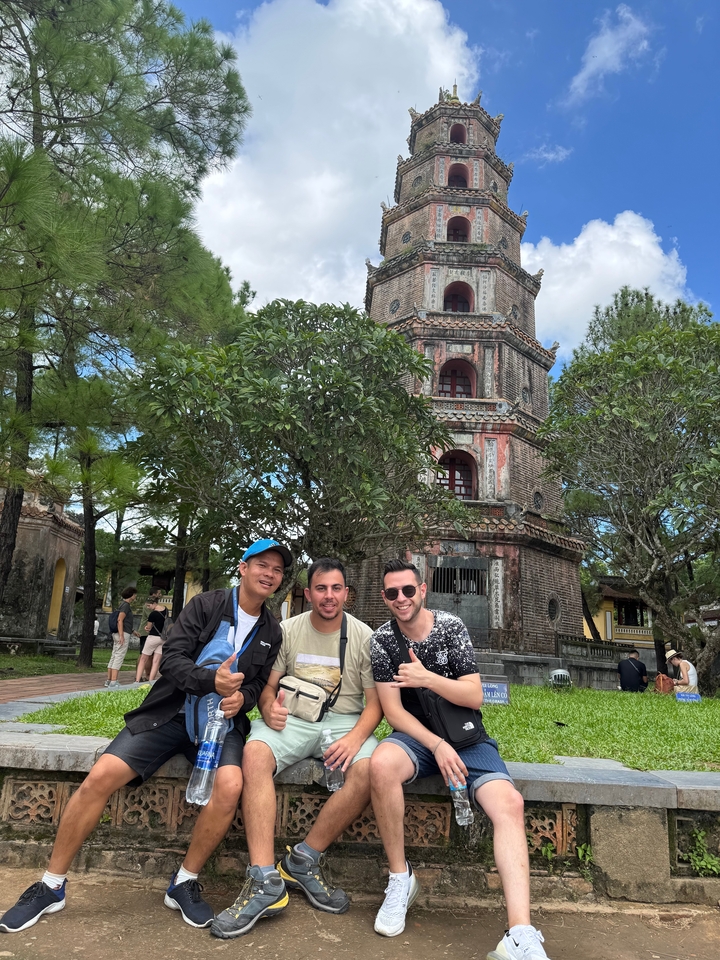 Trois personnes posant devant une pagode.