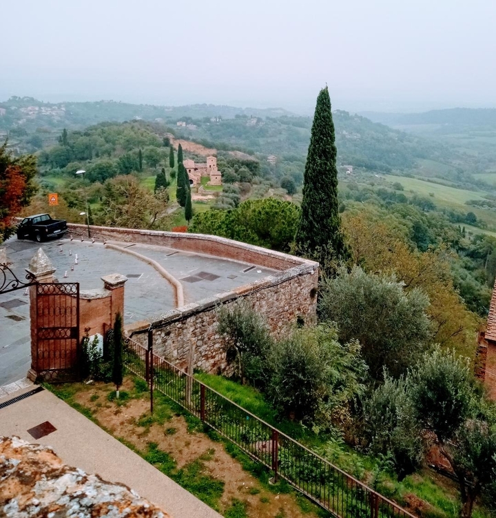 Une vue panoramique de la campagne avec un parking à côté d'un mur de briques.