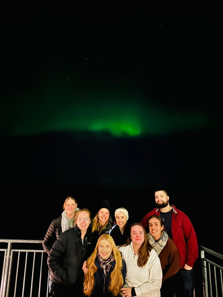 Groupe sous les aurores boréales dans des conditions sombres.