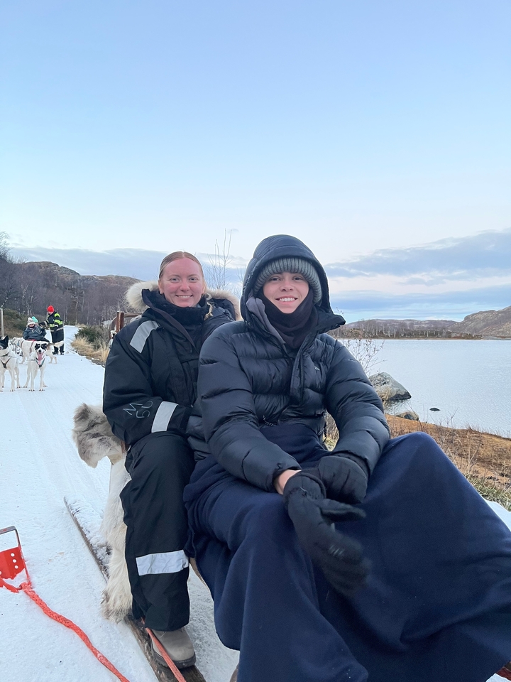 Deux personnes habillées chaudement faisant de la course de chiens de traîneau.
