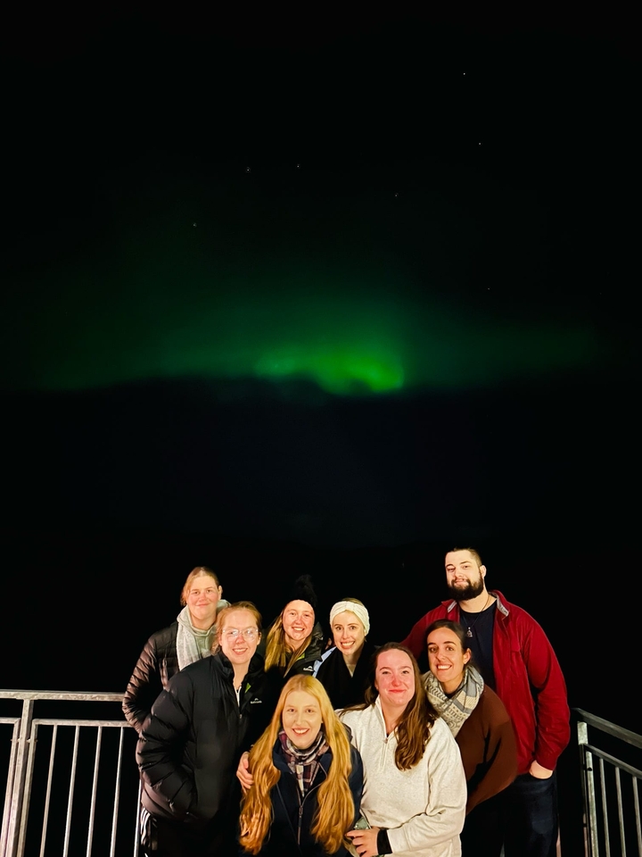 Groupe sous les aurores boréales la nuit.