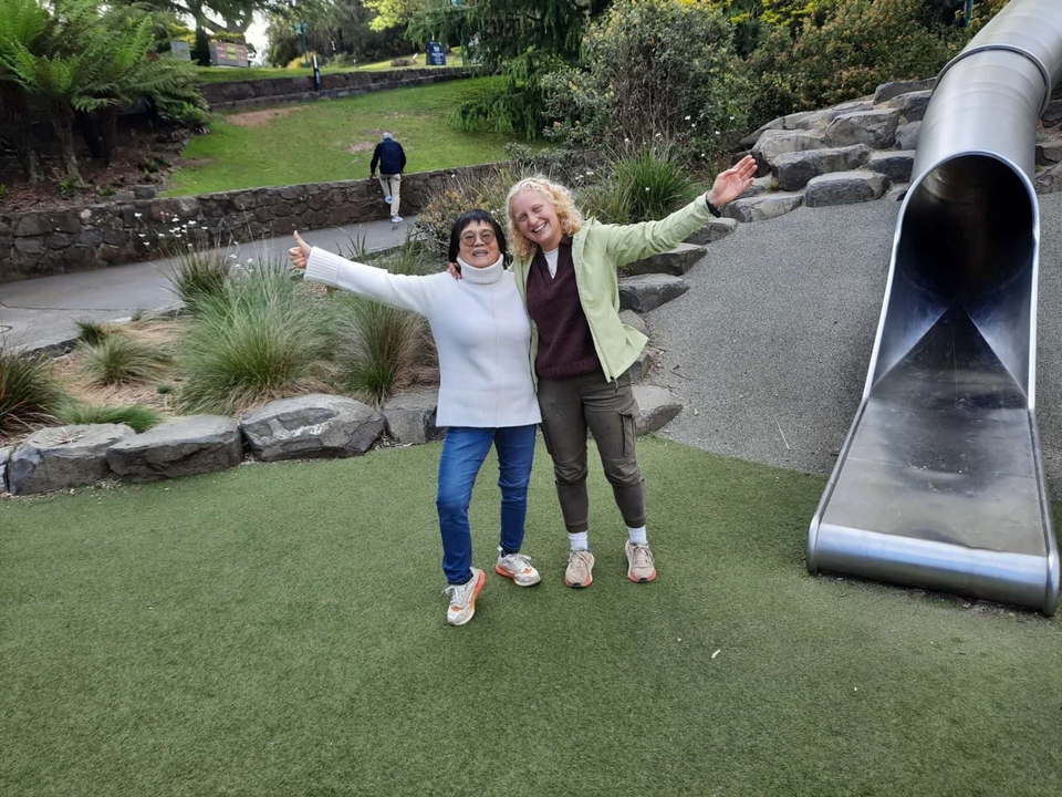 Deux personnes posant devant un toboggan dans un parc.