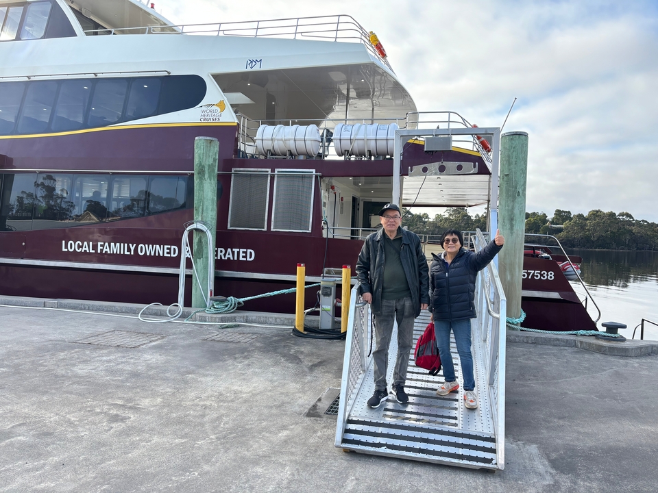 Deux personnes embarquant sur un bateau de croisière local.