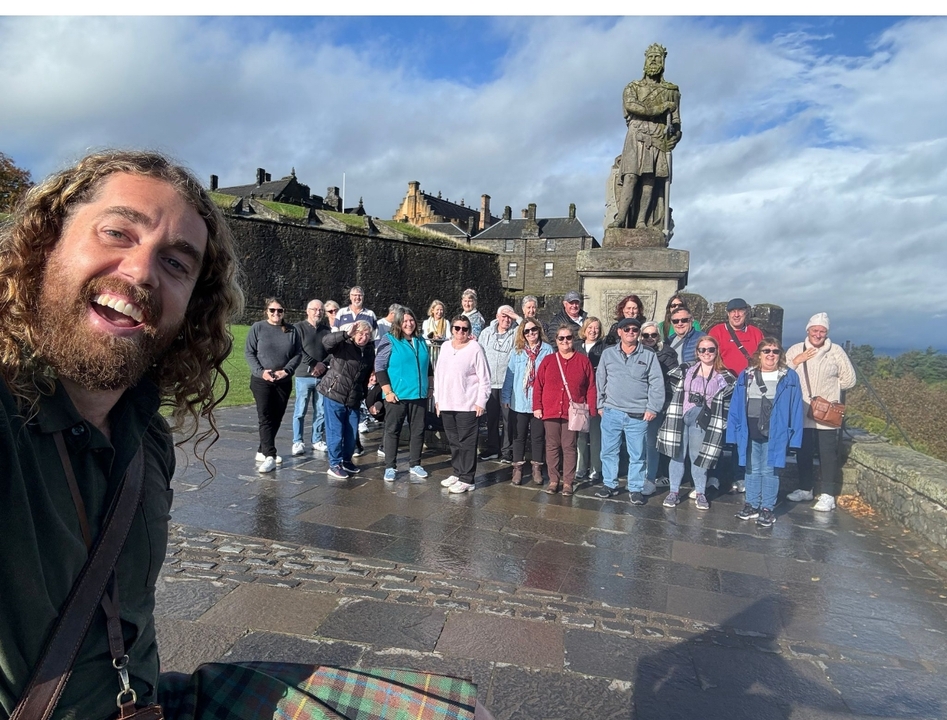 Groupe de touristes avec un guide devant un monument historique.