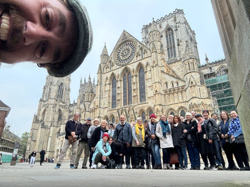 Ein Gruppenfoto von Menschen vor einer Kathedrale mit aufwendiger Architektur.