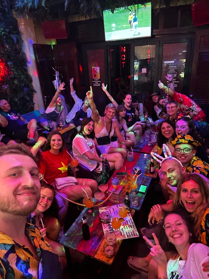 Groupe de personnes faisant la fête avec des lumières vives et des boissons.