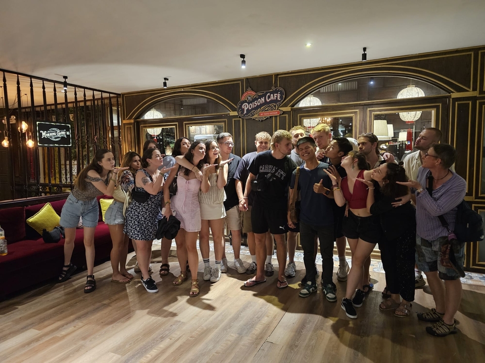 Groupe posant avec des expressions amusantes devant un café.