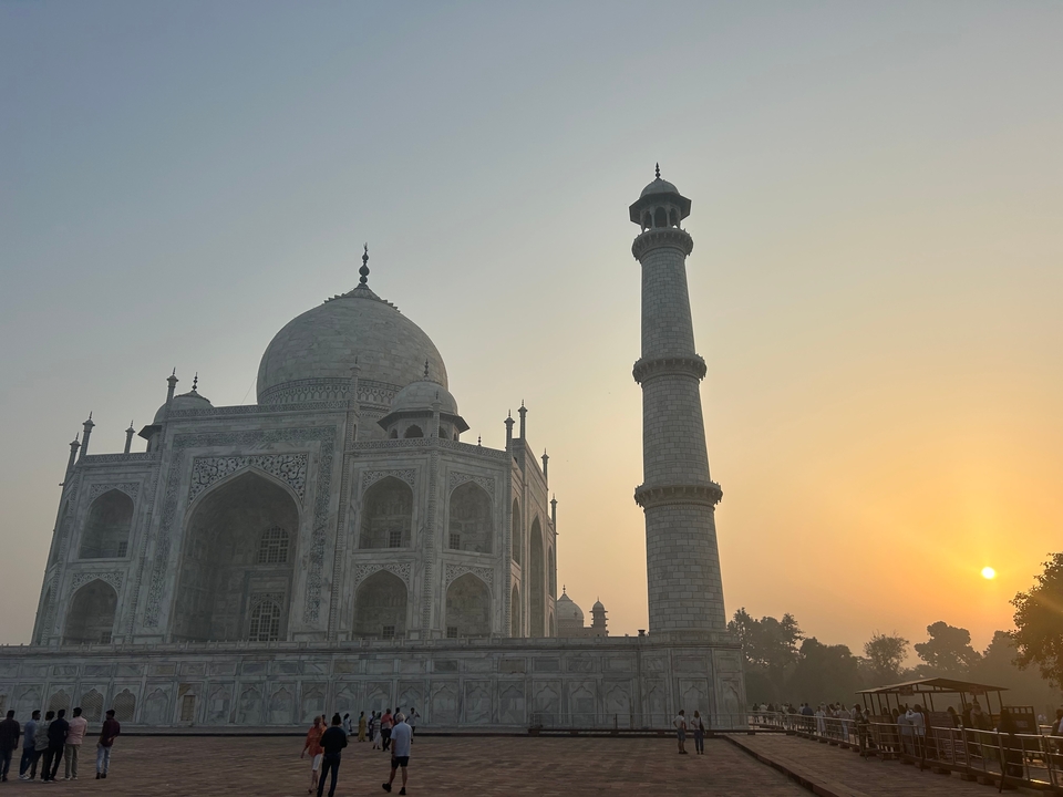 Taj Mahal en silhouette contre un ciel de lever ou coucher de soleil.