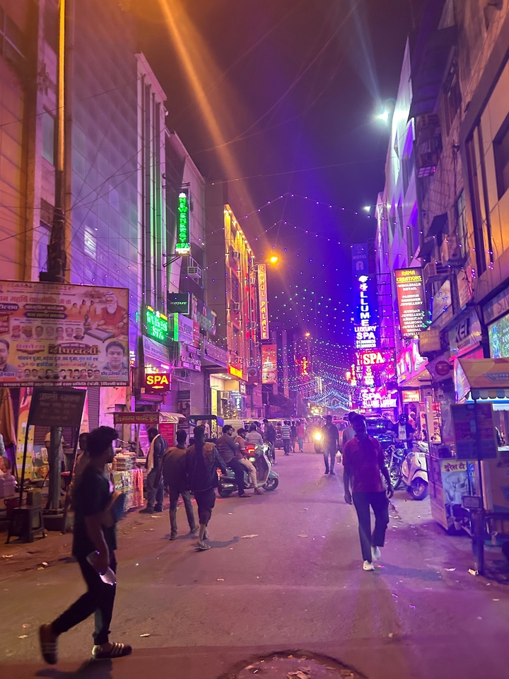 Rue animée la nuit illuminée par des enseignes au néon colorées.