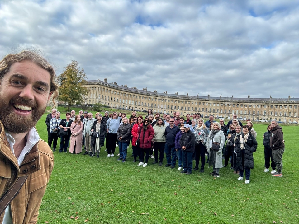 Groupe nombreux posant devant un bâtiment historique en croissant