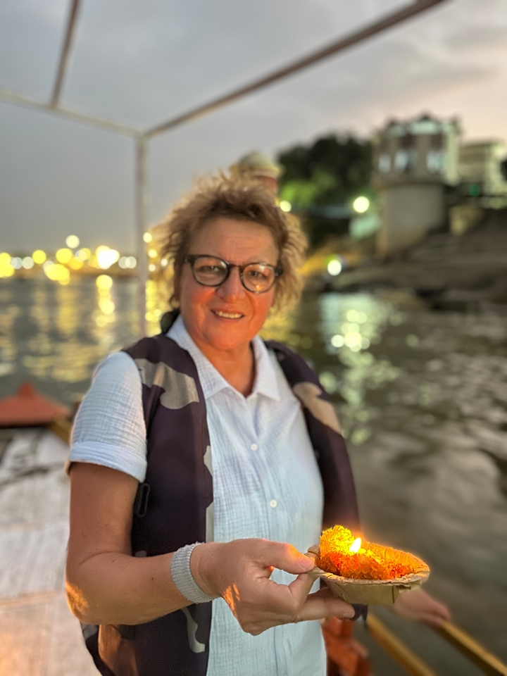 Femme au premier plan avec les lumières de la ville en arrière-plan au crépuscule.