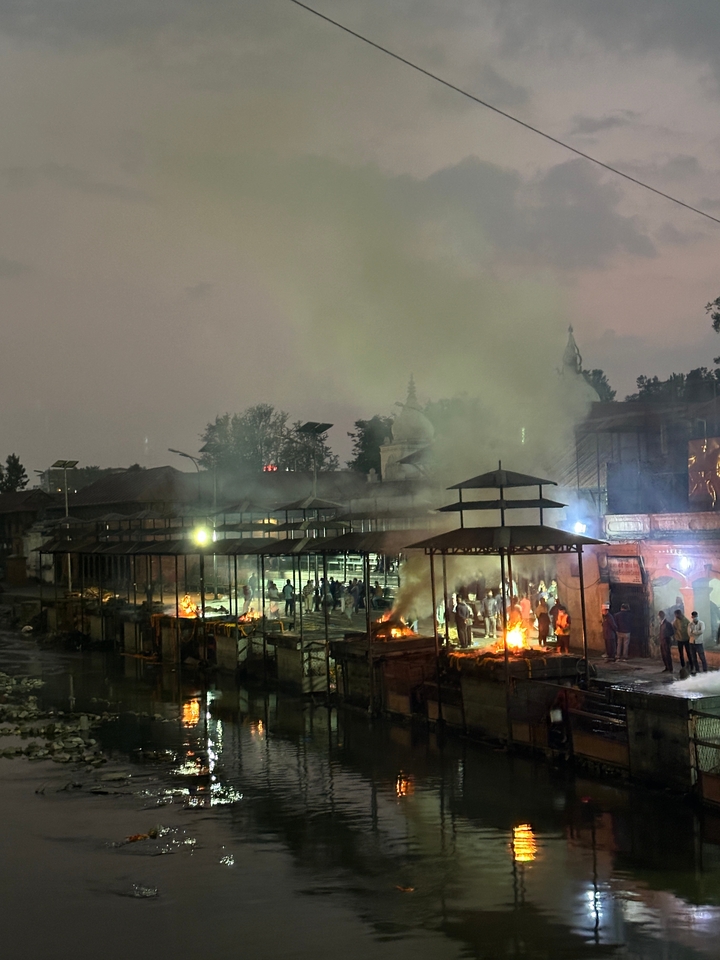 Cérémonie de crémation au bord d'une rivière au crépuscule.
