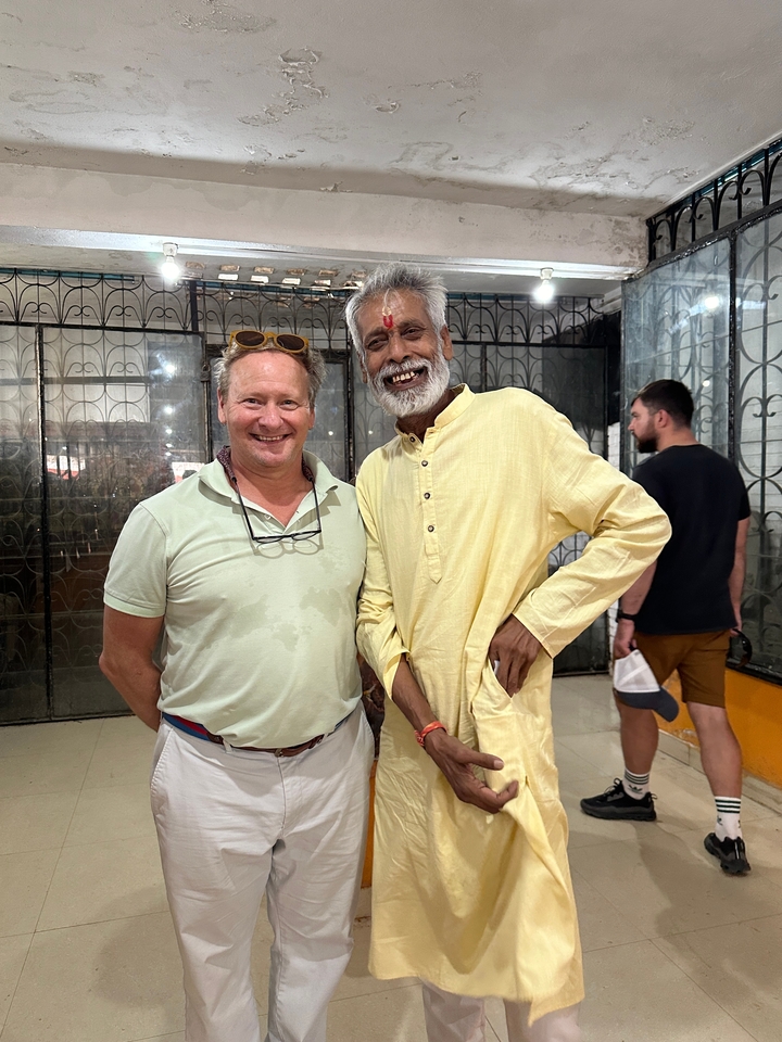Deux hommes debout à l'intérieur souriant à la caméra.