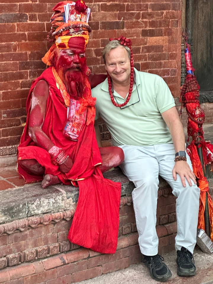 Twee mannen, een gekleed als een heilige man, zittend bij een tempel.