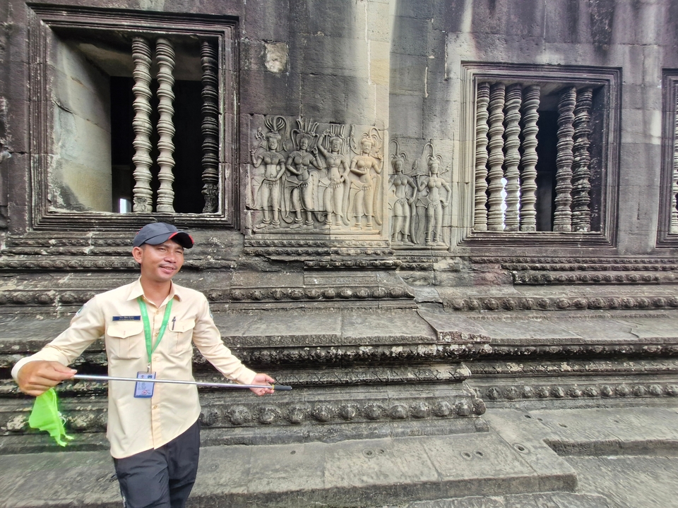 Personne prenant un selfie avec d'anciennes sculptures en pierre.