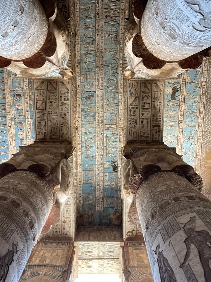 Hiéroglyphes colorés et œuvres d'art au plafond dans un temple antique.