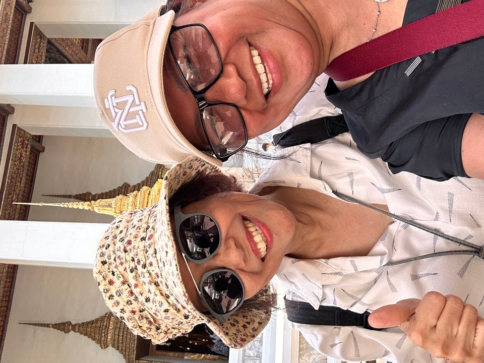 Deux personnes qui prennent la pose pour un selfie avec un temple en arrière-plan.