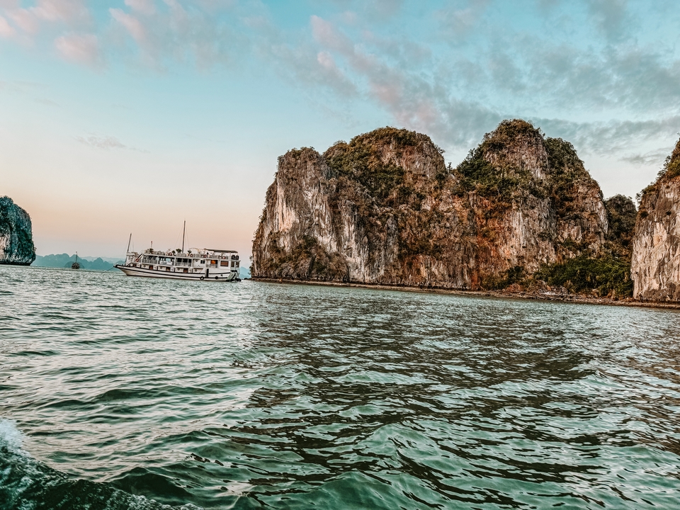 Bateau naviguant sur l'eau avec des falaises rocheuses en arrière-plan