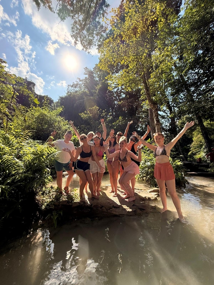 Groupe de personnes dans un environnement de jungle avec la lumière du soleil qui filtre à travers les arbres.