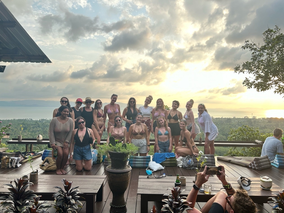 Groupe posant devant un paysage au coucher du soleil.