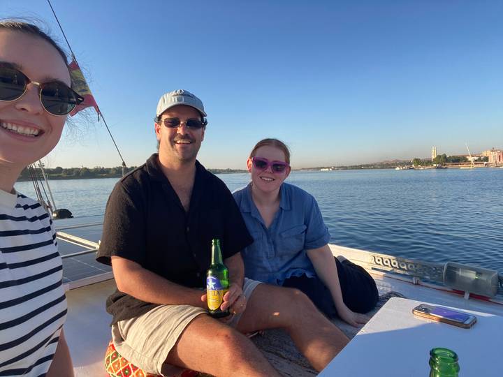 Trois personnes se détendant sur un bateau avec des boissons.