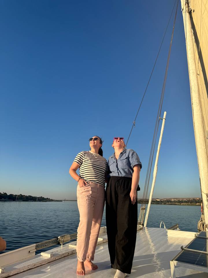 Deux femmes riant sur un bateau par beau temps.