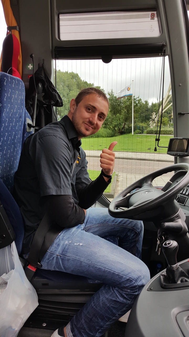 Chauffeur de bus levant le pouce à l'intérieur de la cabine du conducteur.