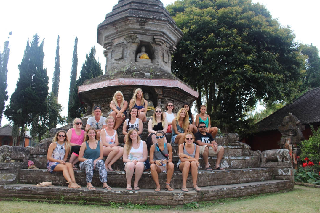 Large group posing in front of a temple structure