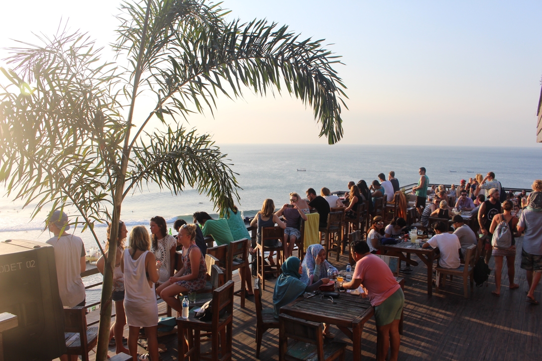 People dining on a terrace overlooking the ocean