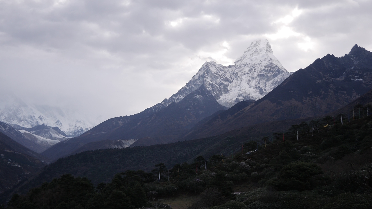 Snow-covered mountain peaks under a cloudy sky.