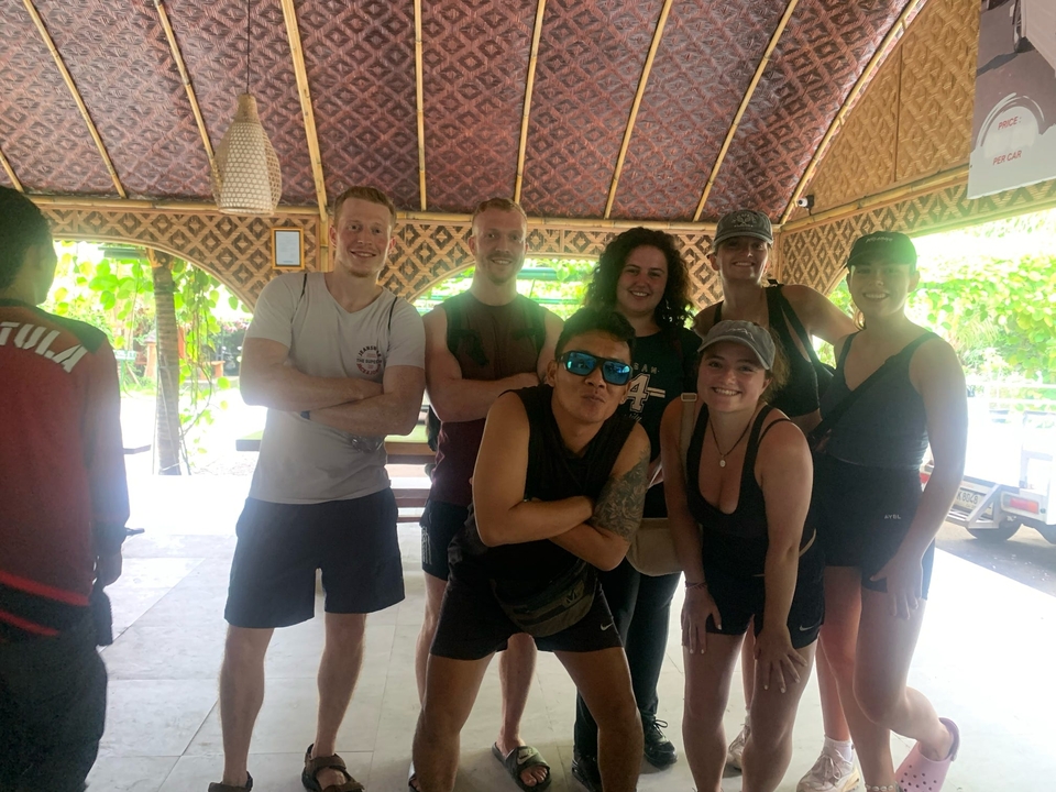 Un groupe de personnes posant à l'intérieur d'un bâtiment rustique.