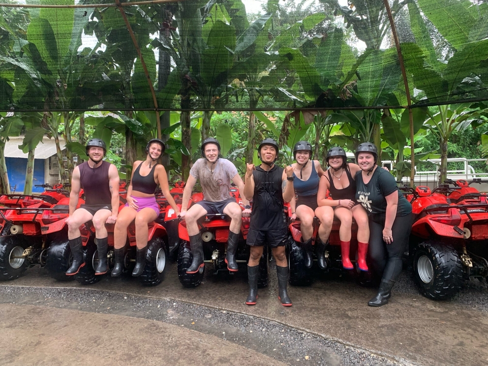 Un groupe de personnes assises sur des VTT sous une canopée de feuilles.