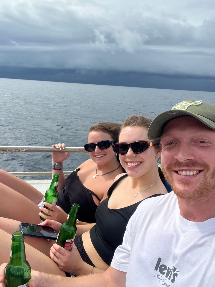Trois personnes se détendant sur un bateau avec des boissons.