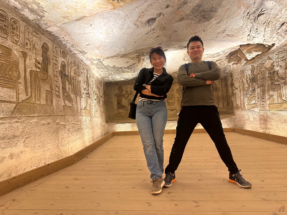 Deux personnes posant à l'intérieur d'un temple égyptien antique.