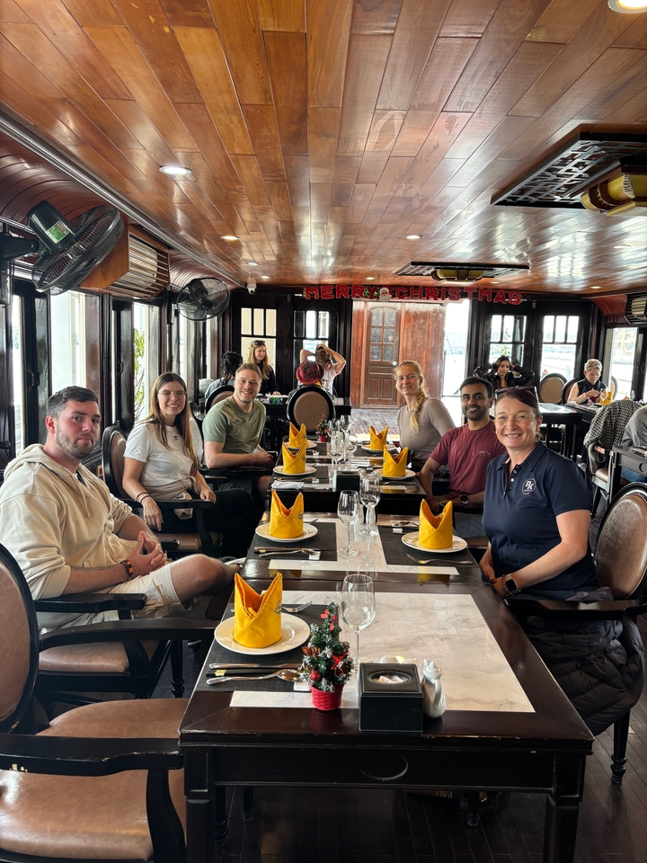 Groupe de personnes dînant à une table avec des décorations festives.